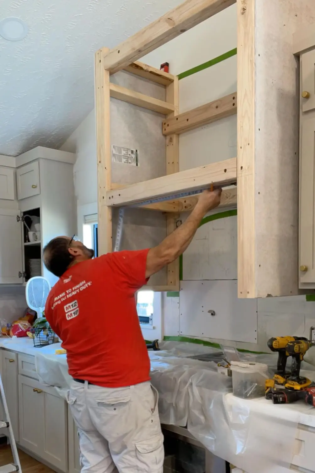 Measuring while building a stone range hood.